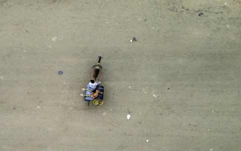 Vista aérea de jóvenes venezolanos transportando agua en un vagón en el campamento de migrantes La Pista en Maicao, departamento de La Guajira, el 24 de abril de 2025.