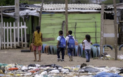 Niños migrantes venezolanos caminan en el campamento de migrantes La Pista en Maicao, departamento de La Guajira, Colombia, el 22 de abril de 2025.