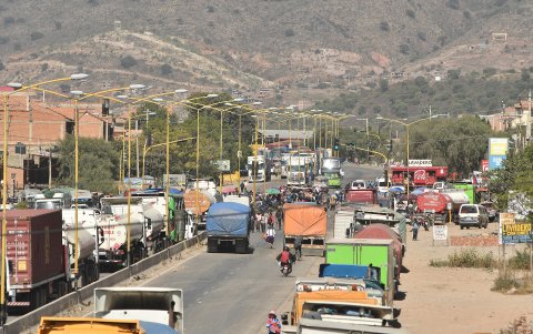 Camiones esperan en una carretera tras un bloqueo realizado por seguidores del exmandatario Evo Morales este lunes, en Sipe Sipe en la región de Cochabamba (Bolivia).