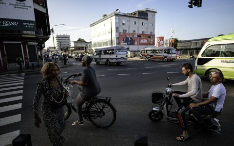 Una mujer cruza una calle frente a bicicletas en Paramaribo el 23 de mayo de 2025.