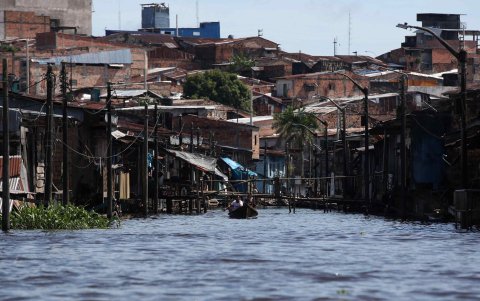 Varias personas transportándose en una canoa por el Barrio de Belén, en Iquitos (Perú).