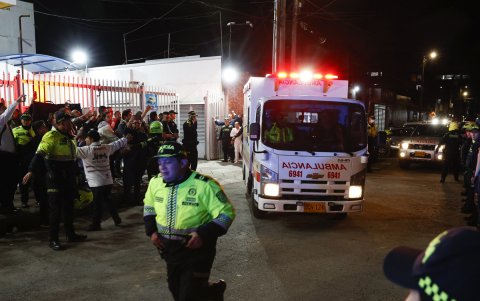 Policías custodian la ambulancia en la que es trasladado el senador Miguel Uribe Turbay, este sábado, en Bogotá (Colombia).