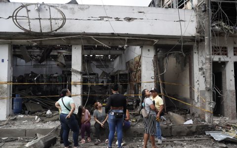 Personas observan los daños ocasionados por una explosión, en Corinto, Cauca (Colombia).