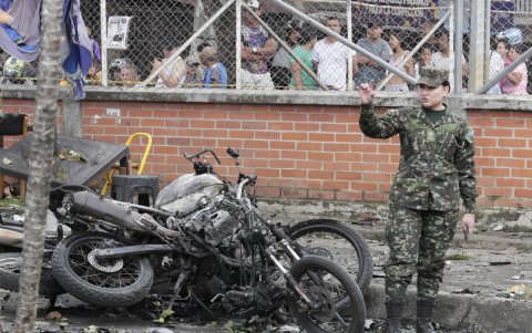 Una integrante del ejército camina al lado de los escombros ocasionados por un atentado ocurrido cerca a la estación de policía del barrio Meléndez