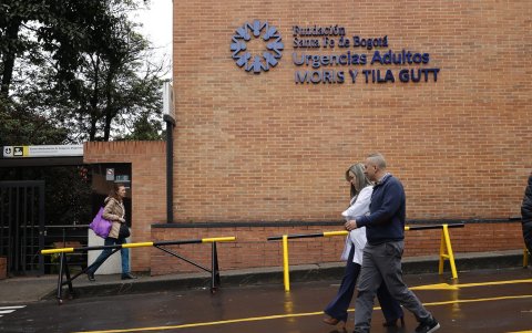 Personas caminan frente a la Fundación Clínica Santa Fe este lunes, donde es atendido el senador y precandidato presidencial Miguel Uribe Turbay en Bogotá (Colombia).
