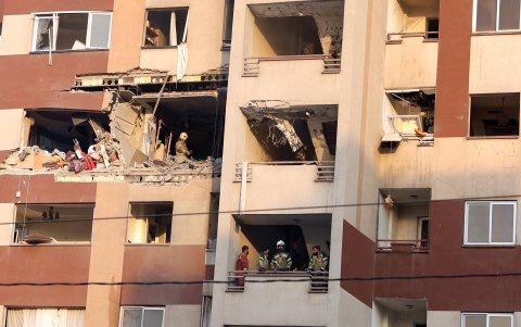 Bomberos trabajan en el interior de un edificio tras un ataque israelí al norte de Teherán, Irán