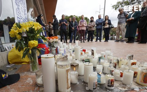 Personas observan un altar en honor al senador y precandidato presidencial colombiano Miguel Uribe Turbay
