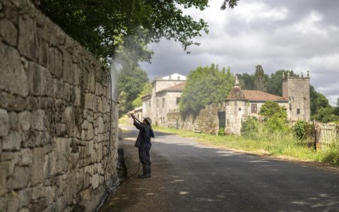 Un trabajador limpia el muro de la vivienda que ha comprado Julio Iglesias en Piñor (Ourense).