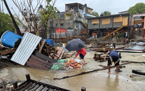 Los lugareños caminan entre los escombros tras el paso del huracán Erick en Bahía Principal, Puerto Escondido, estado de Oaxaca, México, el 19 de junio de 2025.