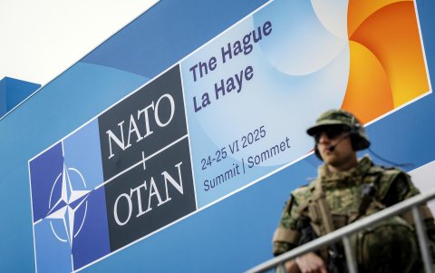 Un soldado hace guardia frente al cartel que anuncia la reunión de la OTAN en La Haya, Países Bajos, que comienza este martes.