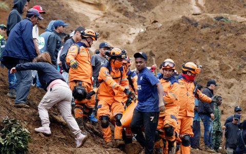Integrantes de la Defensa Civil colombiana trasladan el cuerpo de una persona sin vida este martes, en Bello (Colombia).