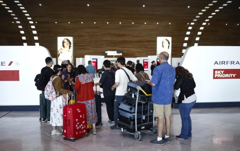 Varios pasajeros se reúnen dentro del aeropuerto Roissy-Charles de Gaulle, tras la huelga de controladores de tráfico aéreo franceses