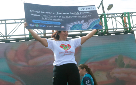 Kerly Briones, presidenta de la Fundación Contamos Contigo Ecuador, sostiene el cheque con la contribución económica a su causa.