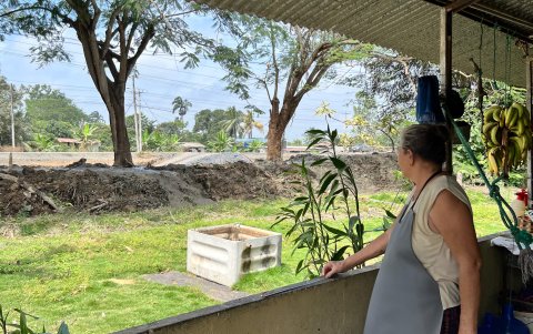 Reina Peñafiel mira desde la entrada de su casa la ampliación de las vías que está haciendo la Prefectura del Guayas; desconoce si le van a expropiar sus bienes o no.