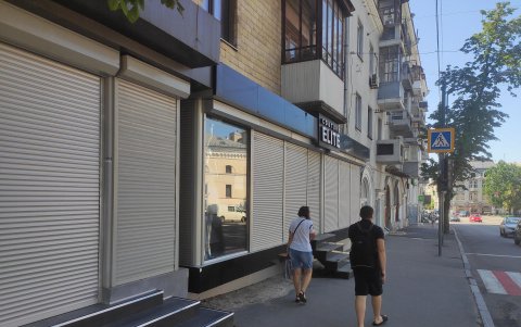 Vista general de paneles de aglomerado cubriendo los escaparates de los negocios locales destruidos por los ataques rusos en Járkov, Ucrania.