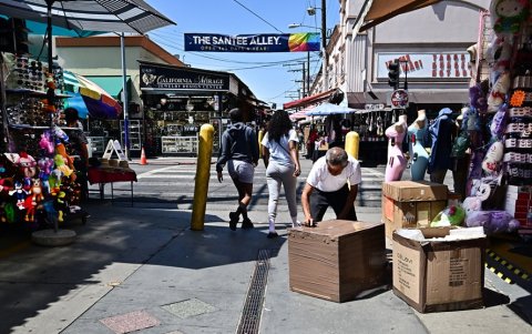 Un comerciante abre cajas frente a un negocio en Santee Alley en el distrito de la moda del centro de Los Ángeles, el 3 de julio de 2025.