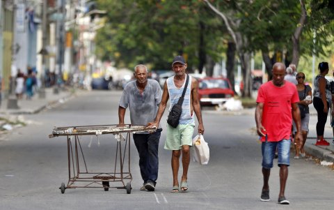 Un anciano camina arrastrando un carro con objetos reciclados en La Habana.