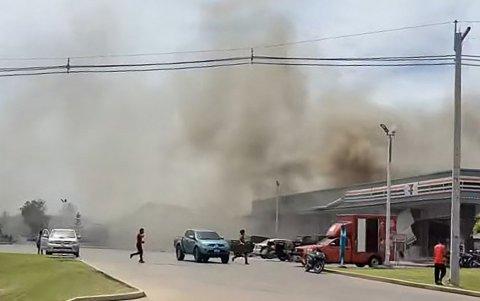 Hay humo saliendo del techo de una tienda de conveniencia junto a una estación de servicio en la provincia de Sisaket después de que fuera alcanzada por un ataque con cohetes desde Camboya.