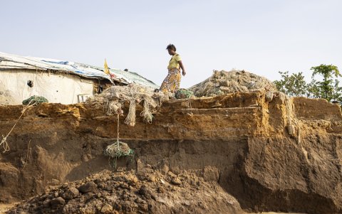 Un residente camina junto a una sección dañada por los efectos del aumento del nivel del mar en la isla Plantain, el 28 de abril de 2025.