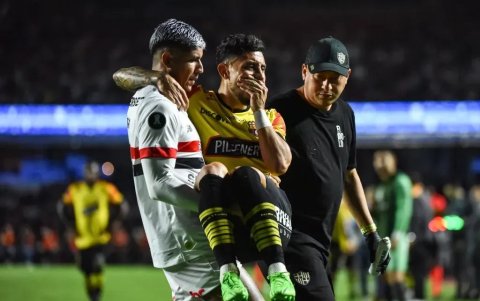 Un jugador de Sao Paulo lleva en sus brazos a Joao Rojas, tras su lesión en el partido ante Barcelona en Copa Libertadores.