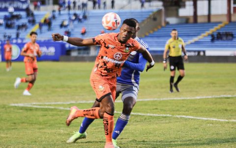 Jugador de Libertad protege la pelota ante el acecho de un futbolista de Emelec.