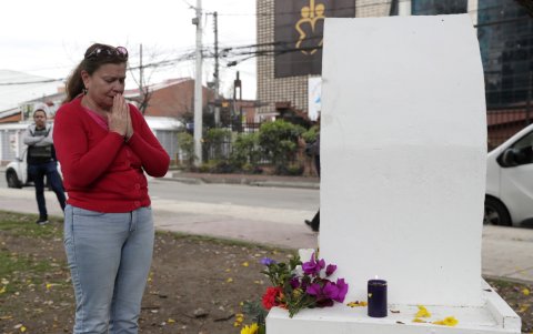 Una persona ora frente a un altar ubicado en el parque El Golfito del barrio Modelia, lugar del atentado contra el senador y precandidato presidencial Miguel Uribe Turbay, este lunes en Bogotá.