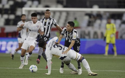 Jefferson Savarino (d) de Botafago disputa el balón con Richard Mina de Liga de Quito en un partido de octavos de final de la Copa Libertadores .