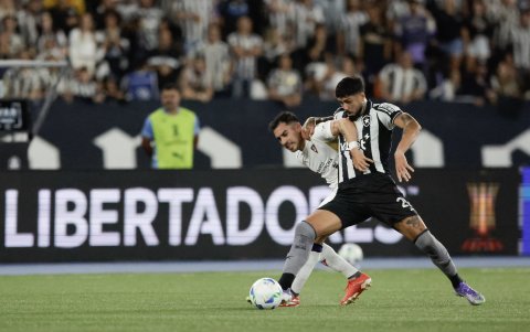 Alexander Barboza (d) de Botafago disputa el balón con Lisandro Alzugaray de  Liga de Quito.