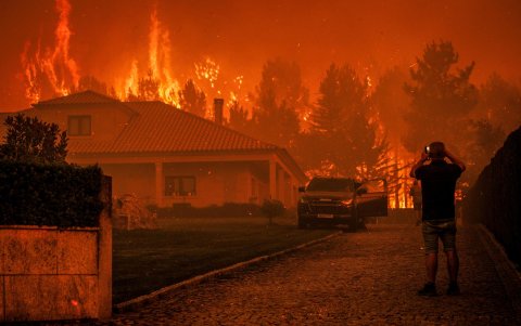 Un hombre observa cómo un incendio forestal se desata cerca de una casa en Granja do Paiva, municipio de Sernancelhe, en Portugal, el 14 de agosto de 2025.