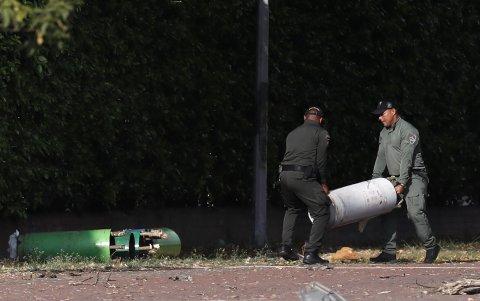 Policías mueven cilindros hallados en la zona del atentado tras una explosión en inmediaciones de la Escuela Militar de Aviación Marco Fidel Suárez este jueves, en Cali (Colombia).