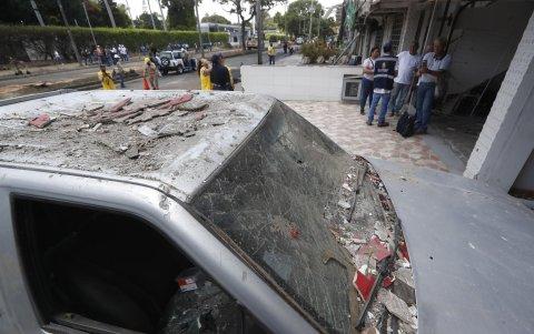 Fotografía que muestra un vehículo afectado por una explosión, este viernes en Cali (Colombia).