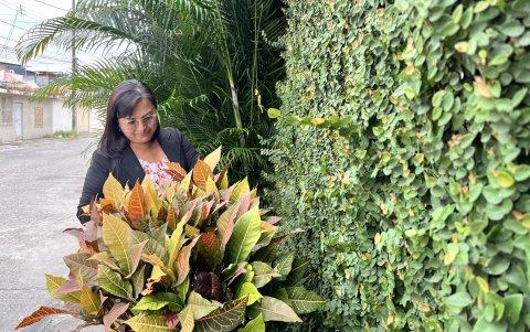 Gina Godoy cuida de las plantas en la fachada de su vivienda, conocida por sus vecinos como la 'Casa de Tarzán' o la 'Casa de la selva'.