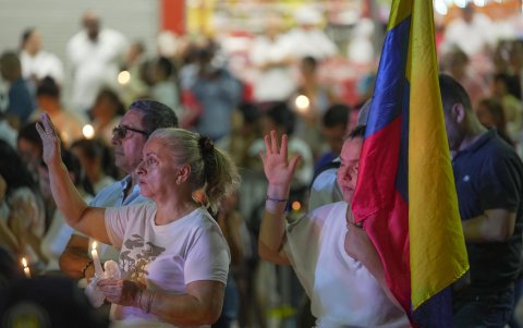 Personas asisten a una 'velatón' por la paz y la memoria este domingo, frente a la Base Aérea Marco Fidel Suárez, en Cali (Colombia).