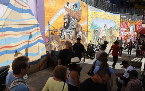 Turistas recorriendo la Comuna 13 en Medellín (Colombia). Medellín, la ciudad que transita entre las montañas y el cielo a bordo de su Metrocable.