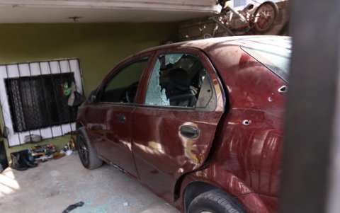 Un vehículo dentro de la vivienda presentaba múltiples orificios de bala luego del ataque.