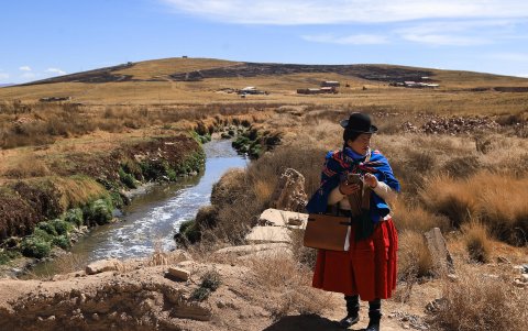 Una mujer aimara camina cerca a un río contaminado este lunes, en Viacha (Bolivia).