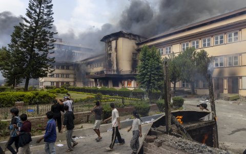 Los manifestantes caminan cerca de objetos en llamas frente al edificio de la Corte Suprema que fue incendiado durante manifestaciones violentas en Katmandú, Nepal, el 9 de septiembre de 2025.