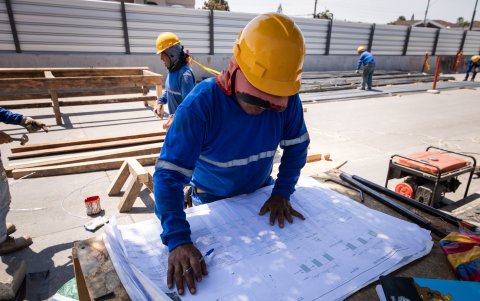 Trabajadores revisan los planos del proyecto de la CAF.