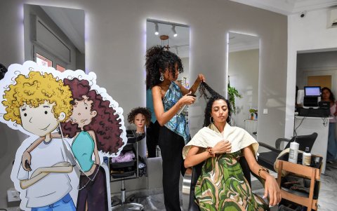 Una clienta se peina en un salón de belleza en Túnez. Durante generaciones, a la gente se le dijo que alisaran, trenzaran o cortaran sus rizos o, de lo contrario, los enviarían a casa.