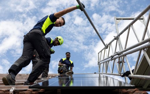 Los empleados de la empresa Solarbau24 instalan paneles solares en un tejado en una obra en construcción en Lohra, cerca de Marburgo, Alemania.