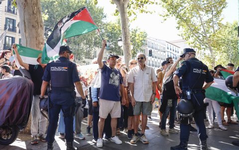Varias personas con banderas palestinas protestan en el Paseo de la Castellana, este domingo, durante la última etapa de la Vuelta a España.