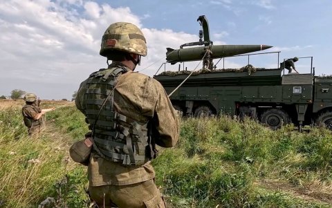 Fotografía de referencia de un militar frente a maquinaria belica.