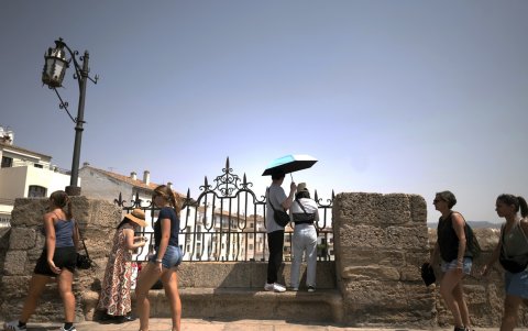 Los turistas se protegen del sol bajo una sombrilla durante una ola de calor en Ronda el 17 de agosto de 2025.
