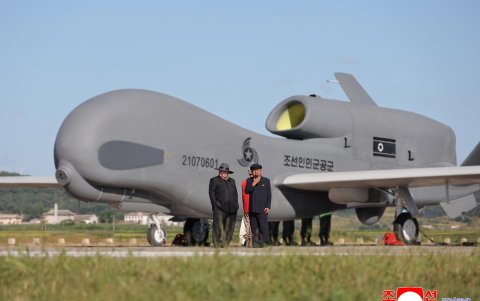 El líder norcoreano Kim Jong-Un (izq.) presidiendo una prueba de rendimiento de drones de ataque táctico y otros vehículos aéreos no tripulados.