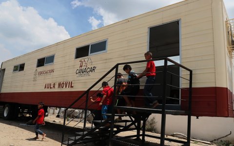 Niños salen de una aula móvil en la comunidad de 