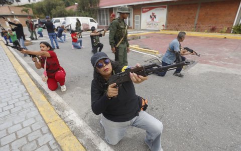 Miembros de los Consejos Comunitarios y Cívicos sostienen rifles durante un entrenamiento militar sobre armamento, en Fuerte Tiuna en Caracas.