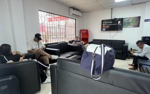 Viajeros se sientan en la sala de espera a reflexionar si viajan, debido a que la ruta alterna, por el cierre de la vía Cuenca-Molleturo, les significa seis horas y treinta minutos de viaje.