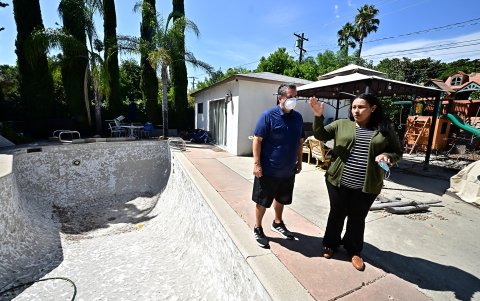 Priscilla Munoz y su esposo junto a la piscina en su casa en Pasadena, a la que habían sometido a pruebas para detectar sustancias químicas tóxicas después del incendio de Eaton de enero de 2025.