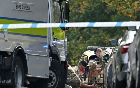 Miembros de las Fuerzas Armadas trabajan junto a un camión de desactivación de bombas mientras preparan un robot multimisión Harris T7 dentro de un cordón policial en la sinagoga.