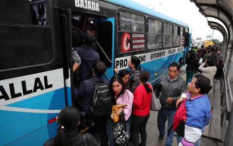 Personas intentan subir a un bus de servicio público este lunes, en Lima (Perú).